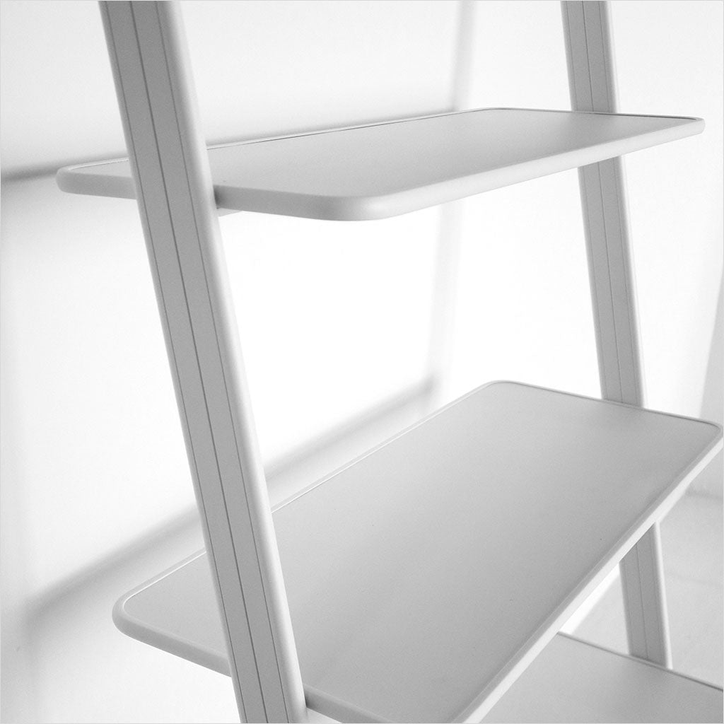 white leaning bookcase