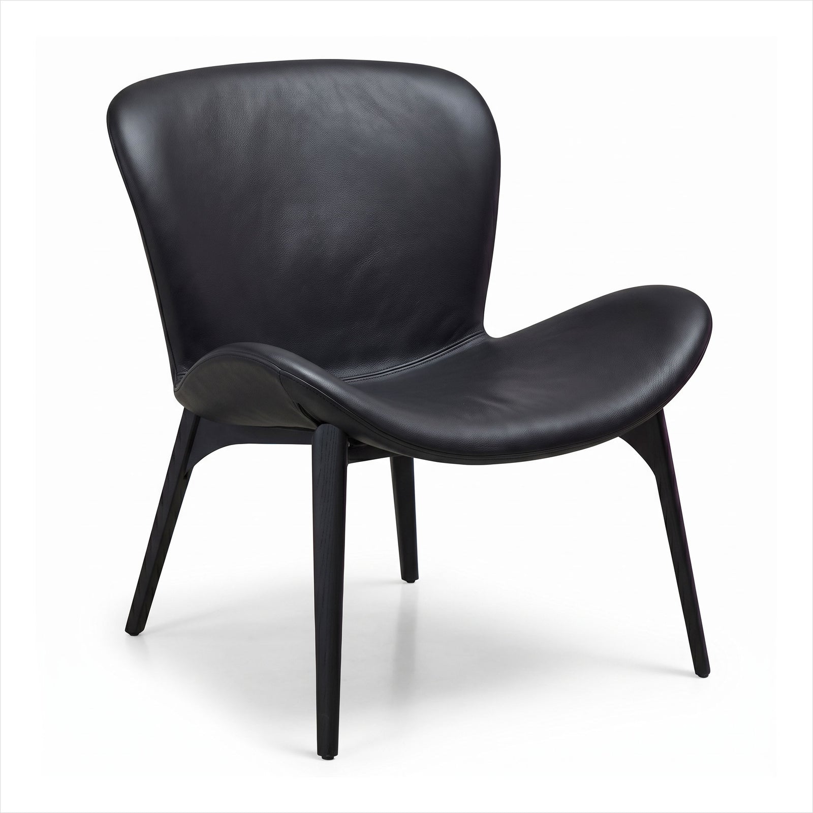 A modern black leather lounge chair with a curved shell back and seat, supported by four tapered black legs, shown on a white studio background.