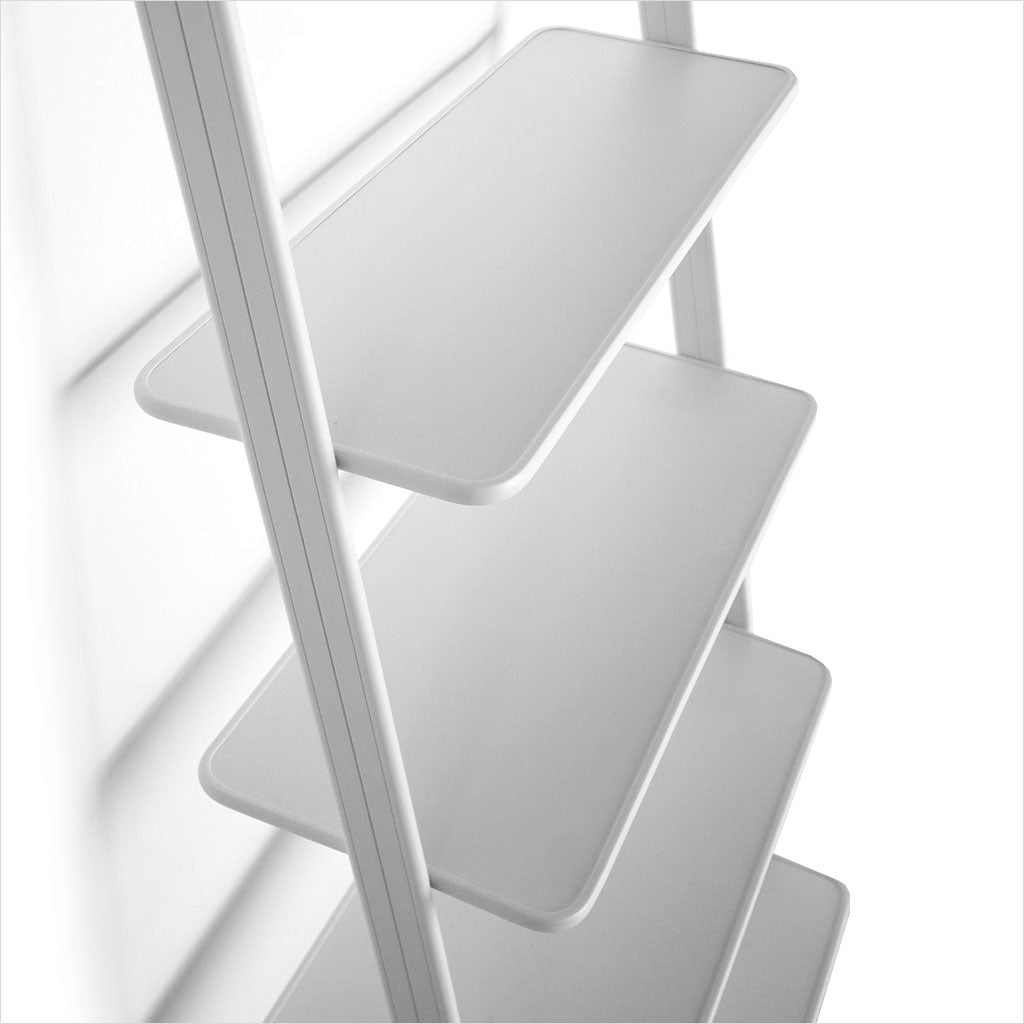 white leaning bookcase